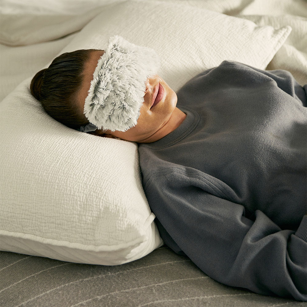 woman wearing warmies heatable eye mask