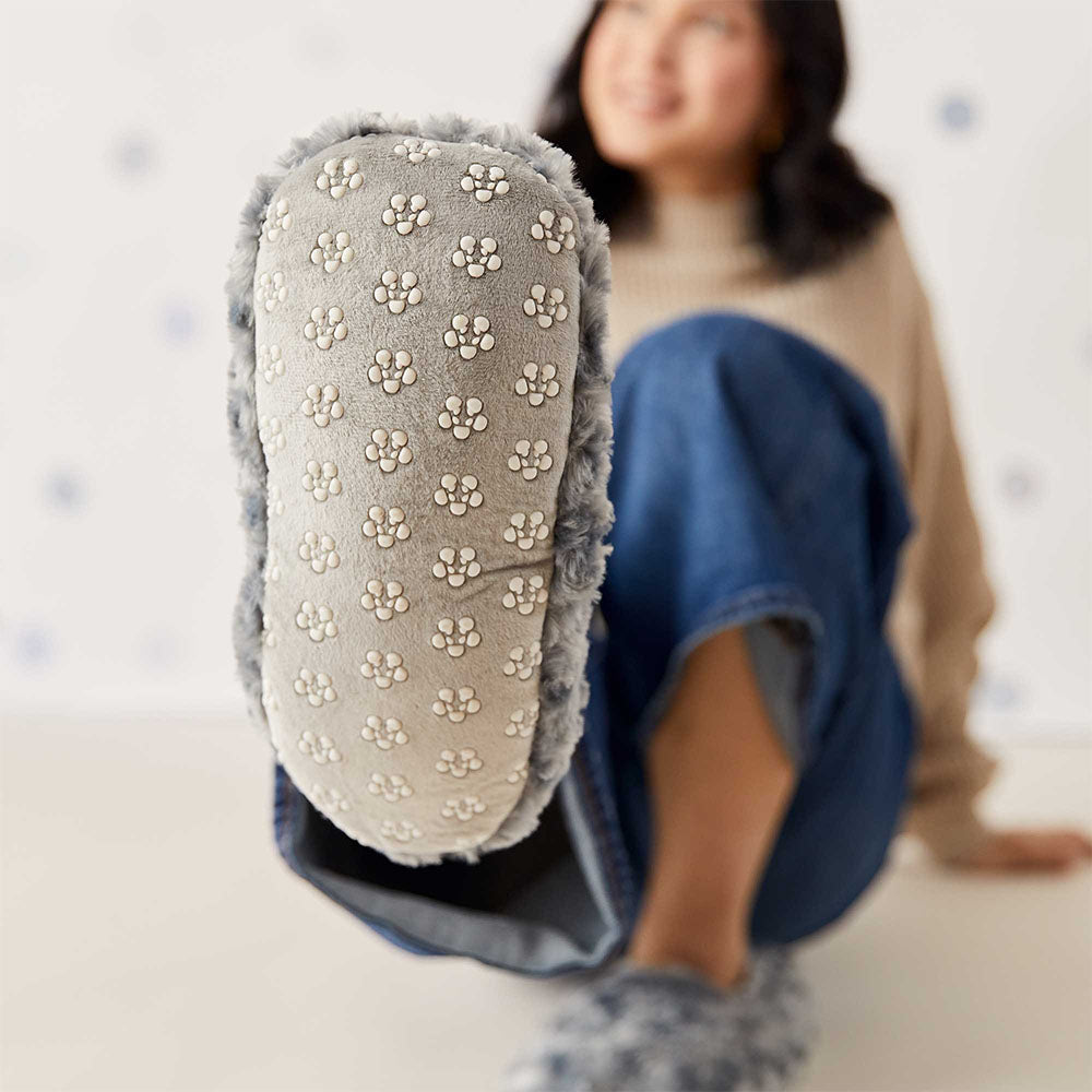 woman wearing warmies slippers showing bottom of slipper