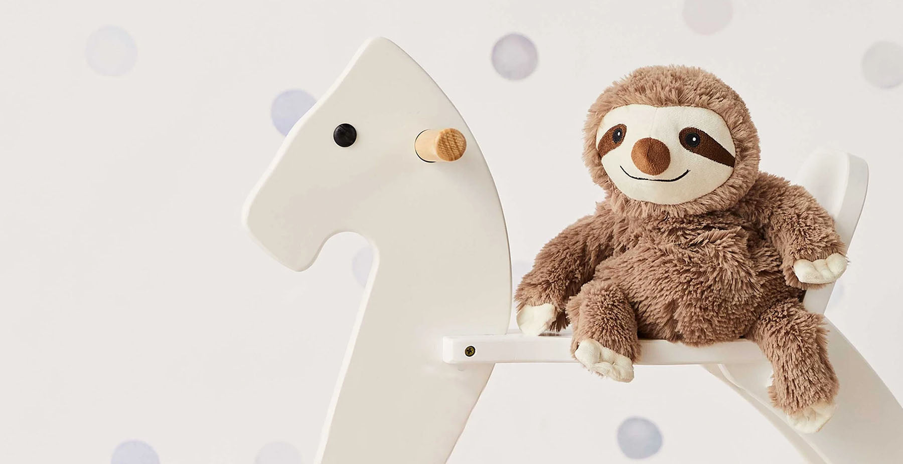 sloth stuffed animal warmies on a rocking horse