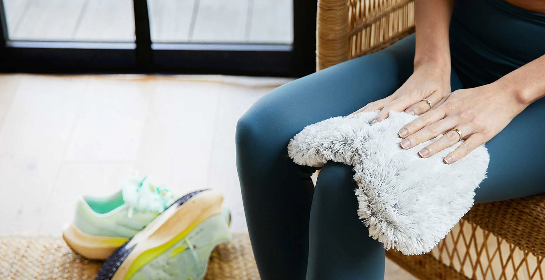 woman using warmies heart shaped heating pad on her knee