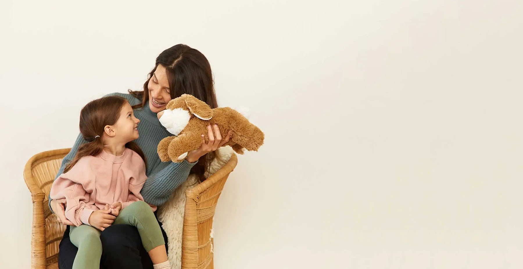 mom and daughter playing with bunny stuffed animal warmies