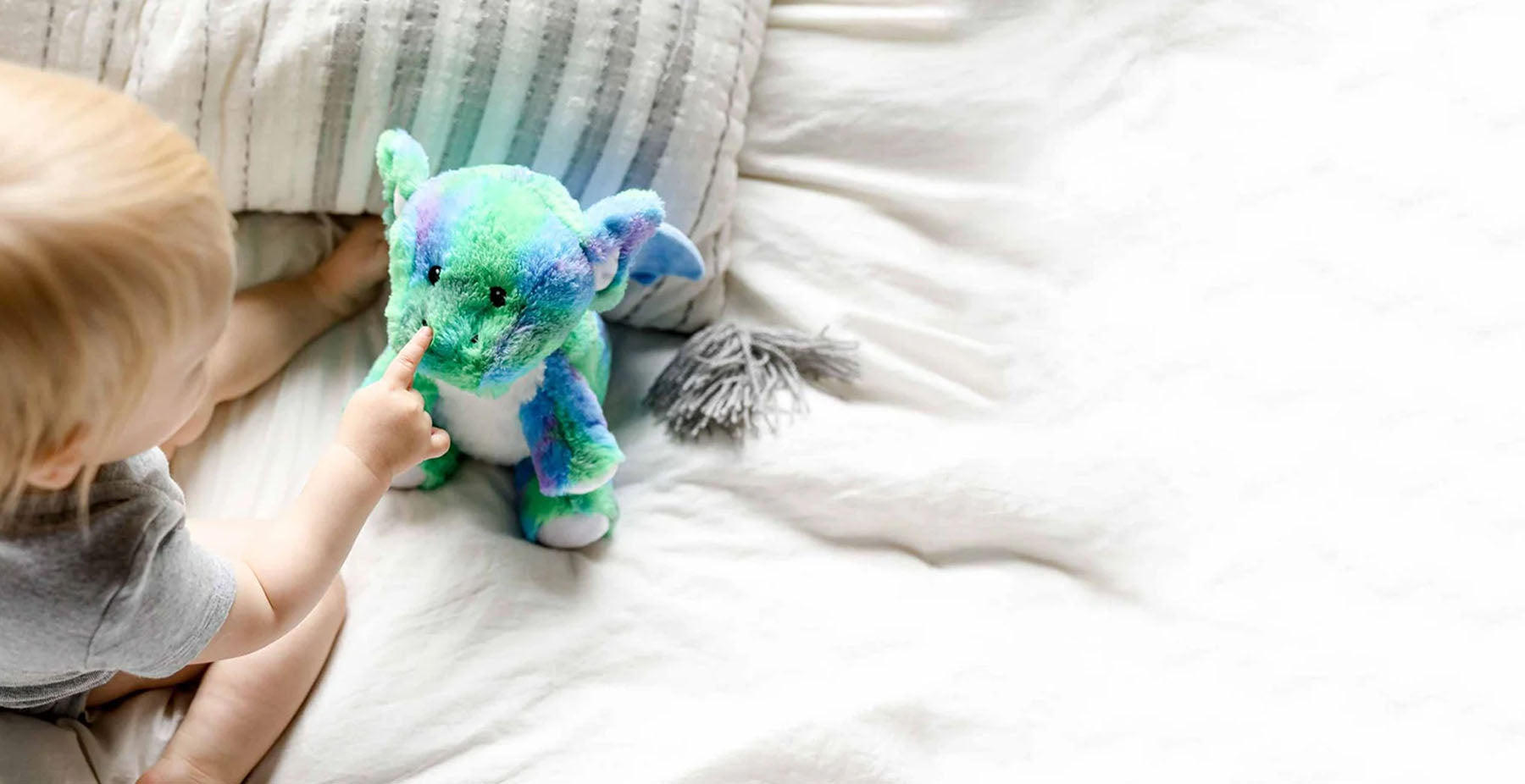 baby with dragon stuffed animal warmies