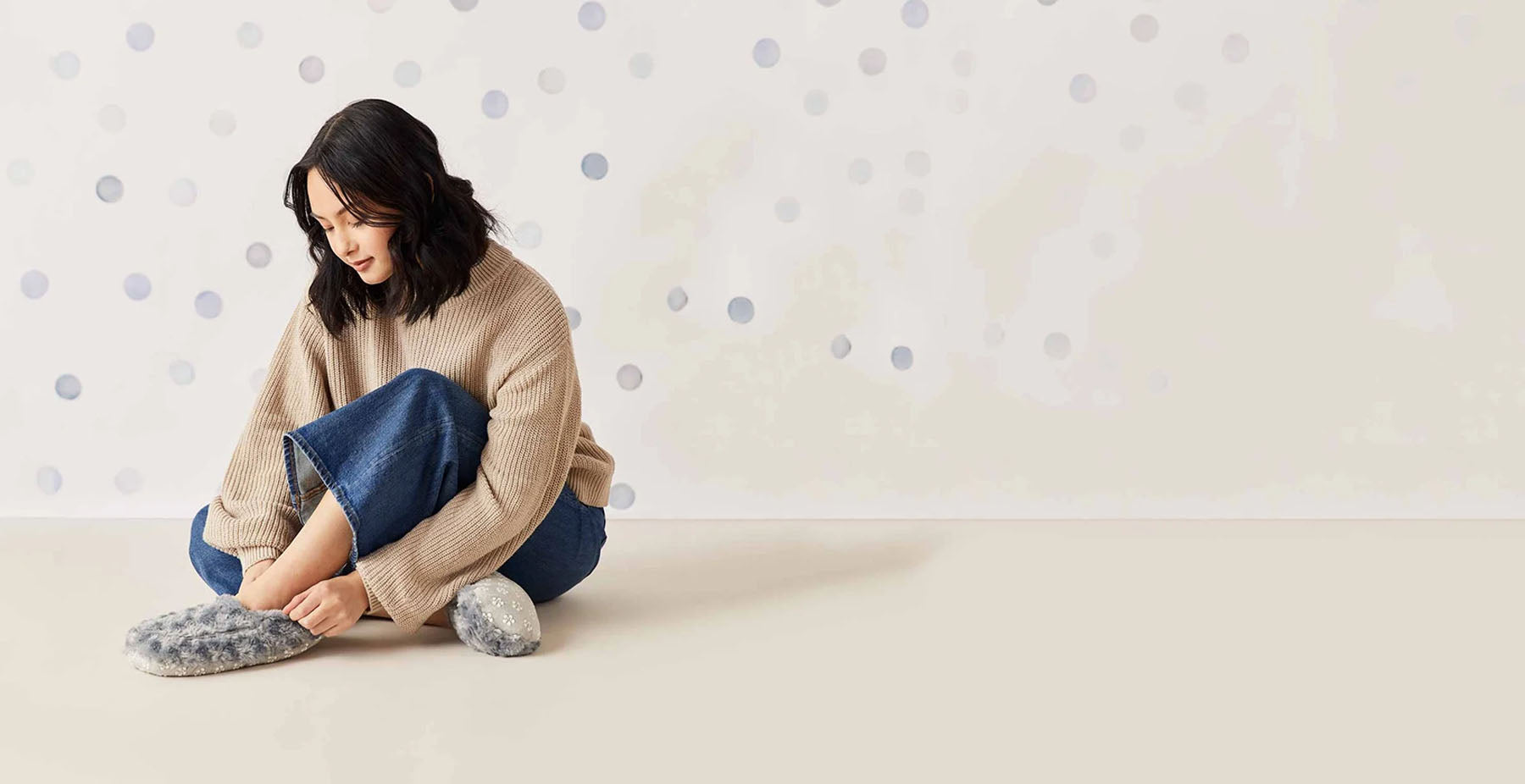 woman wearing gray warmies slippers