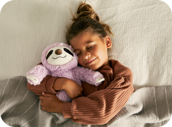 Child cuddling with their Sloth Warmies.