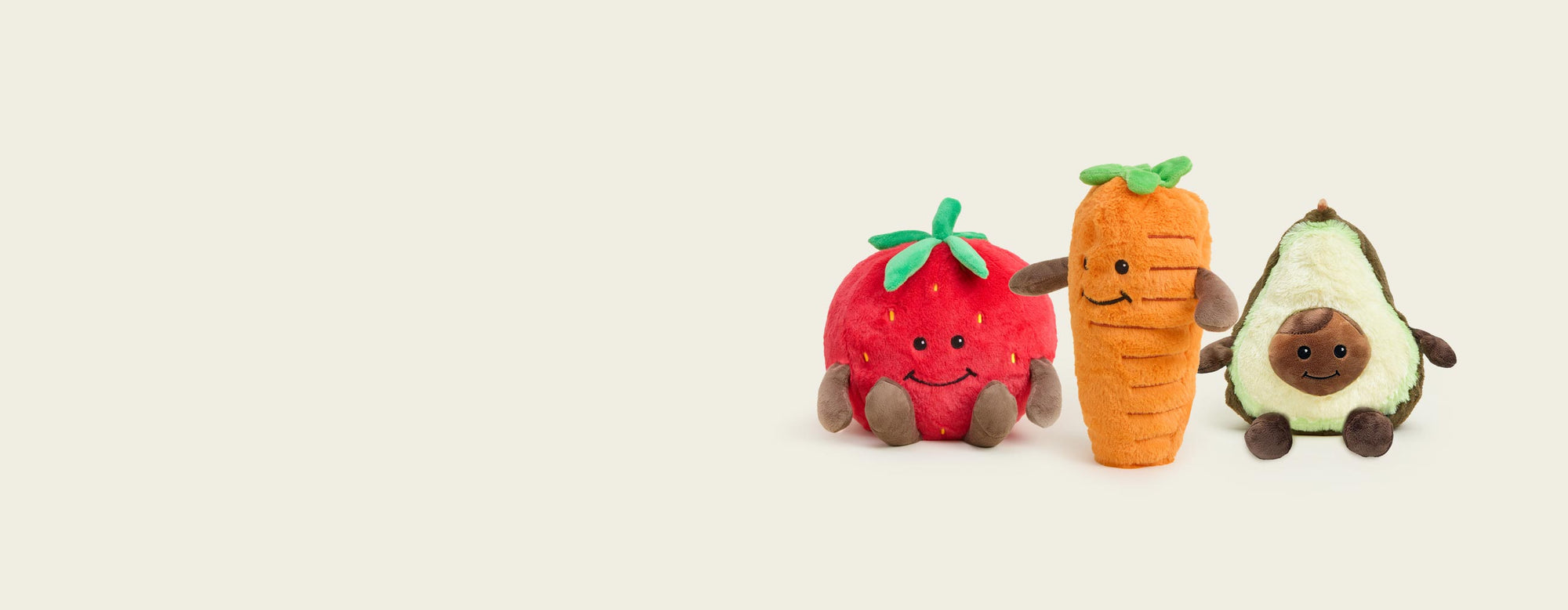 Strawberry, Carrot, Avocado Warmies sitting side by side.