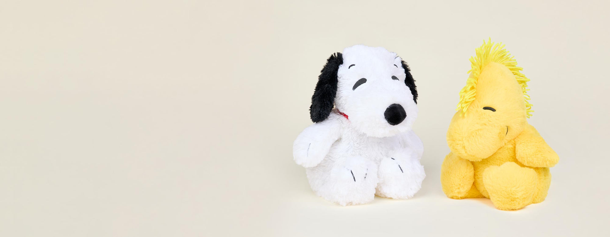 Snoopy and Woodstock Warmies sitting side by side.