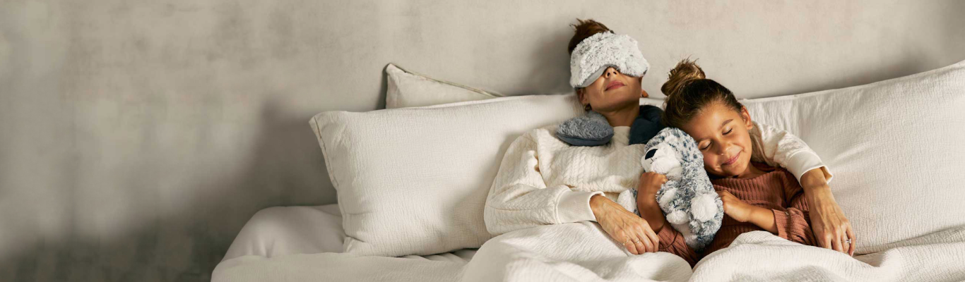 Mother and daughter enjoying the soothing Warmies in bed.
