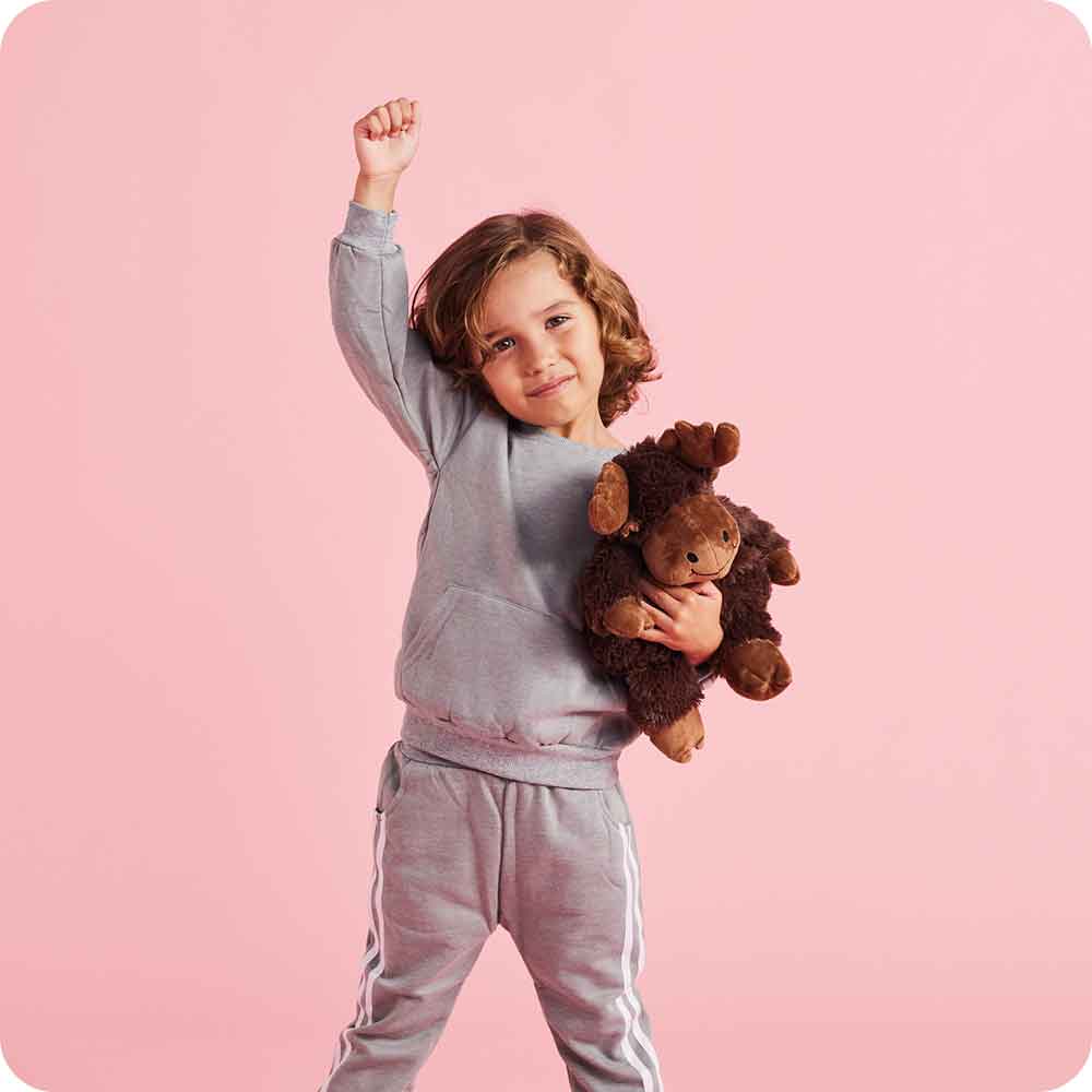 Little boy standing up and holding Soft Warm Weighted Moose Plush Warmies
