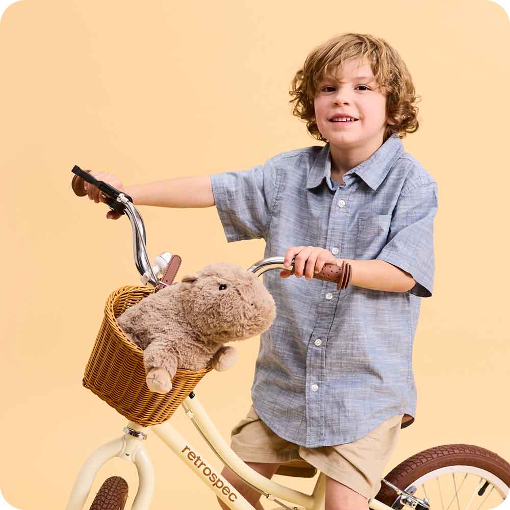 Boy on bicycle with Cute Weighted Lavender Scented Capybara Stuffed Animal Heating Pad Warmies