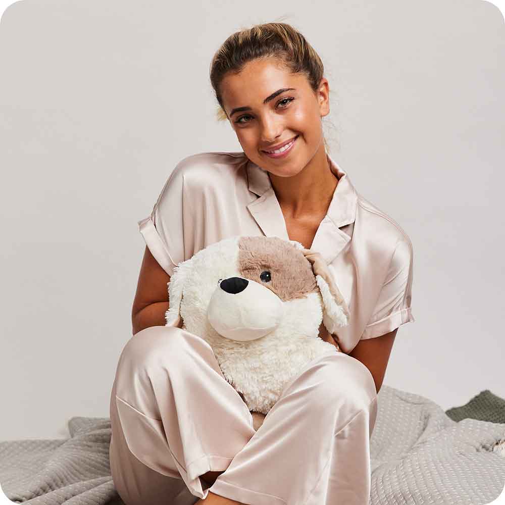 Woman sitting and holding a Microwavable Lavender Scented Supersized Puppy Warmies