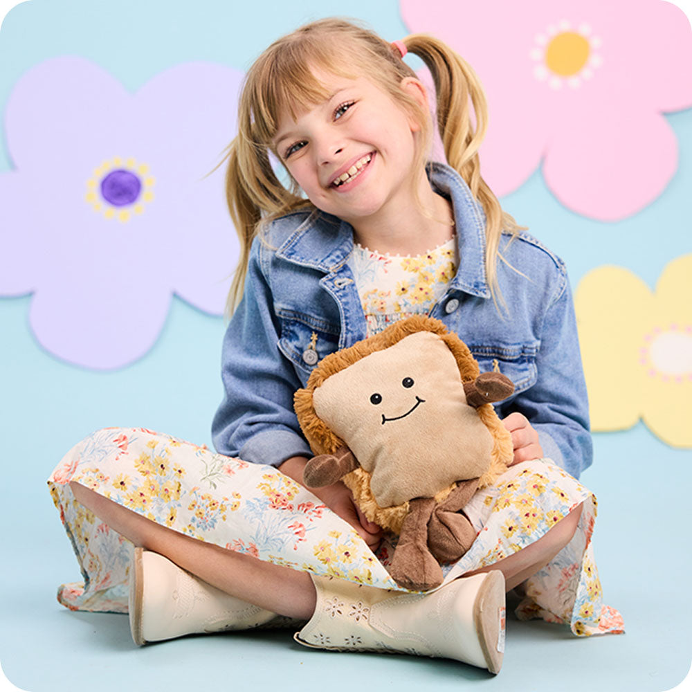 girl holding bread stuffed animal warmies