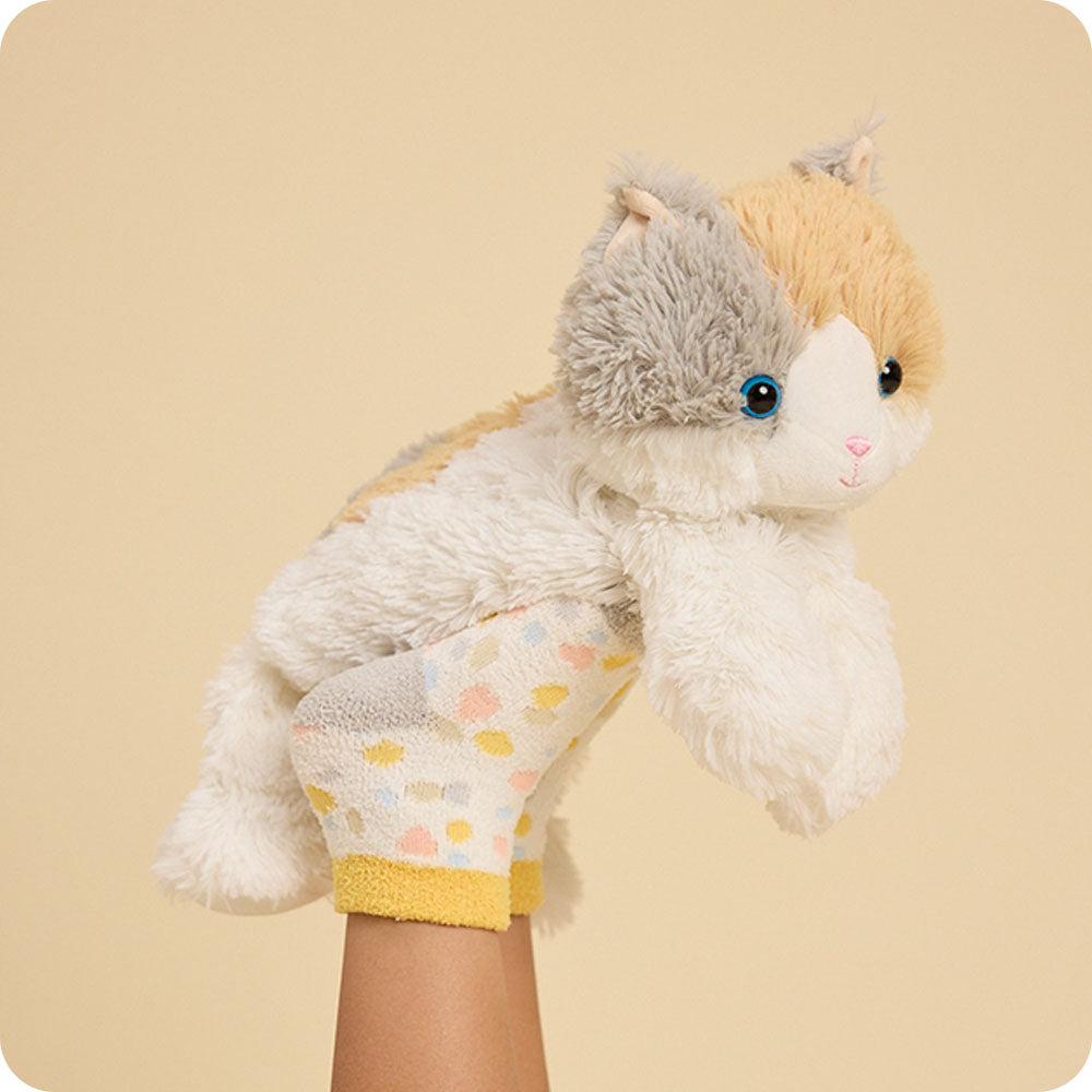 calico cat stuffed animal resting on kids feet