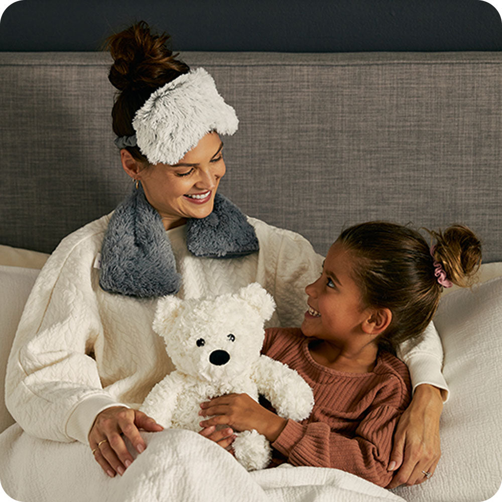 cream curly bear lifestyle cuddling in bed