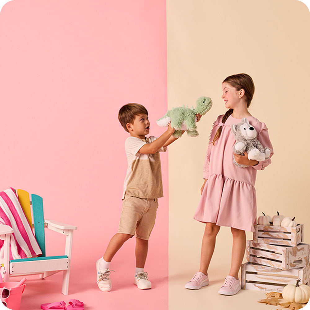 boy holding green long neck dino stuffed animal