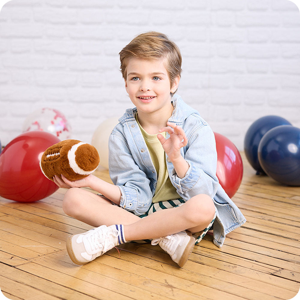 boy holding football stuffed animal