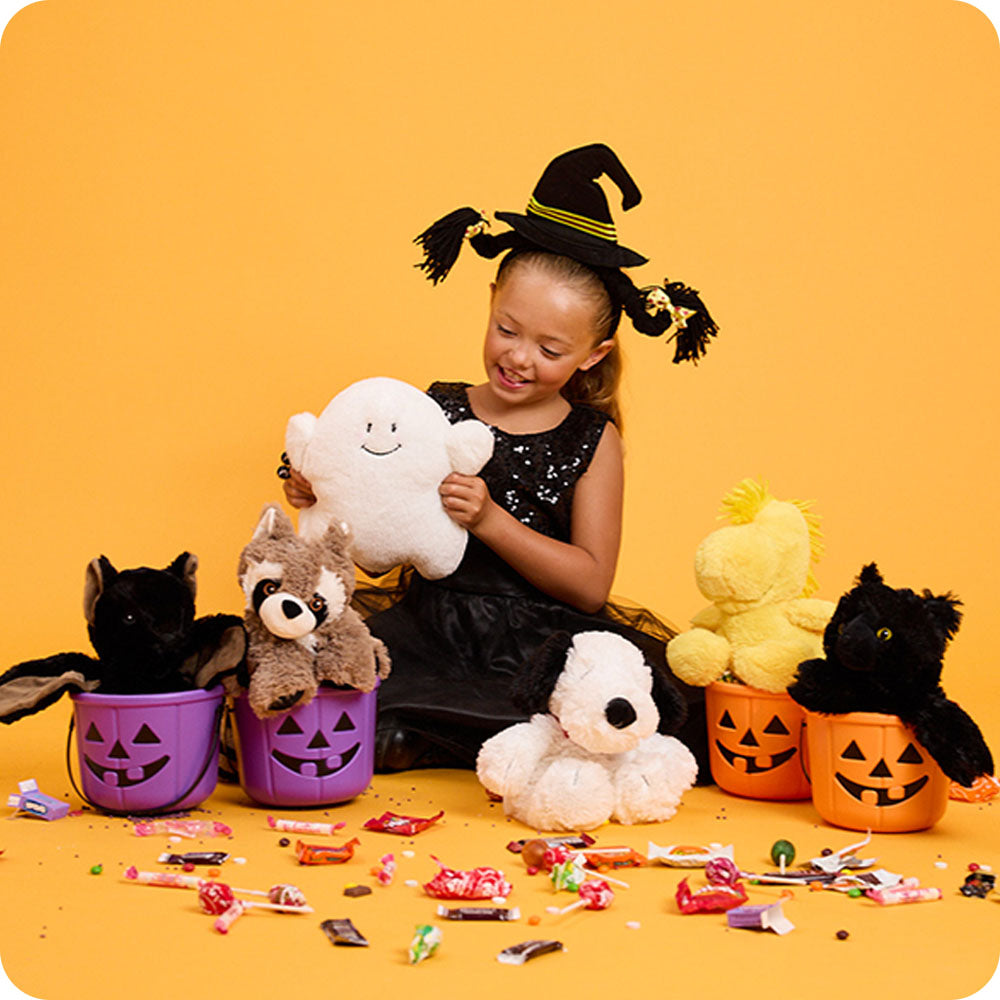 girl dressed for halloween with ghost stuffed animal warmies