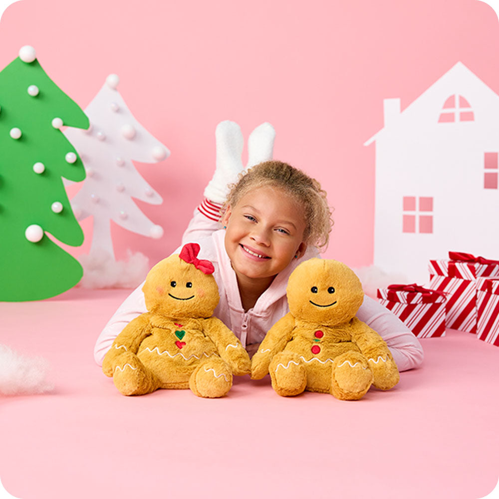 girl cuddling gingerbread girl and boy stuffed animal warmies