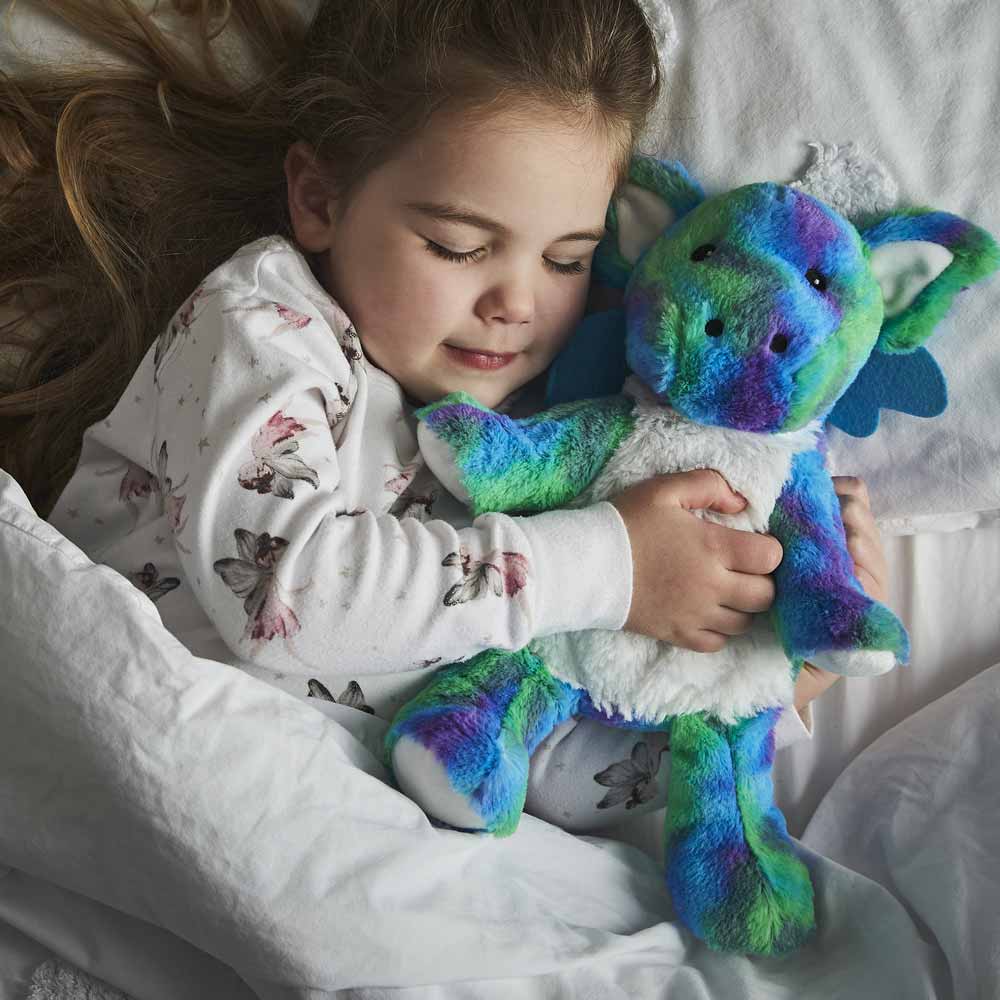 girl sleeping with heatable dragon stuffed animal warmies