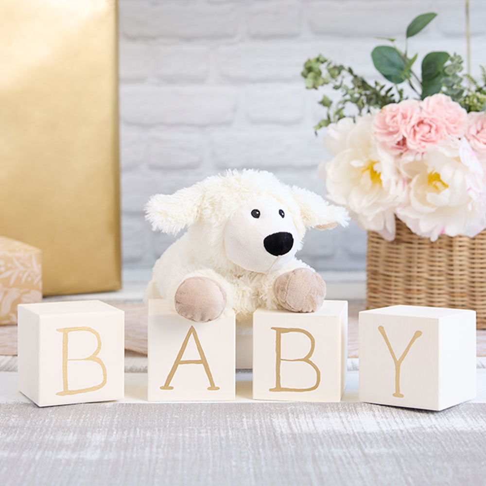 laying down sheep stuffed animal on baby blocks