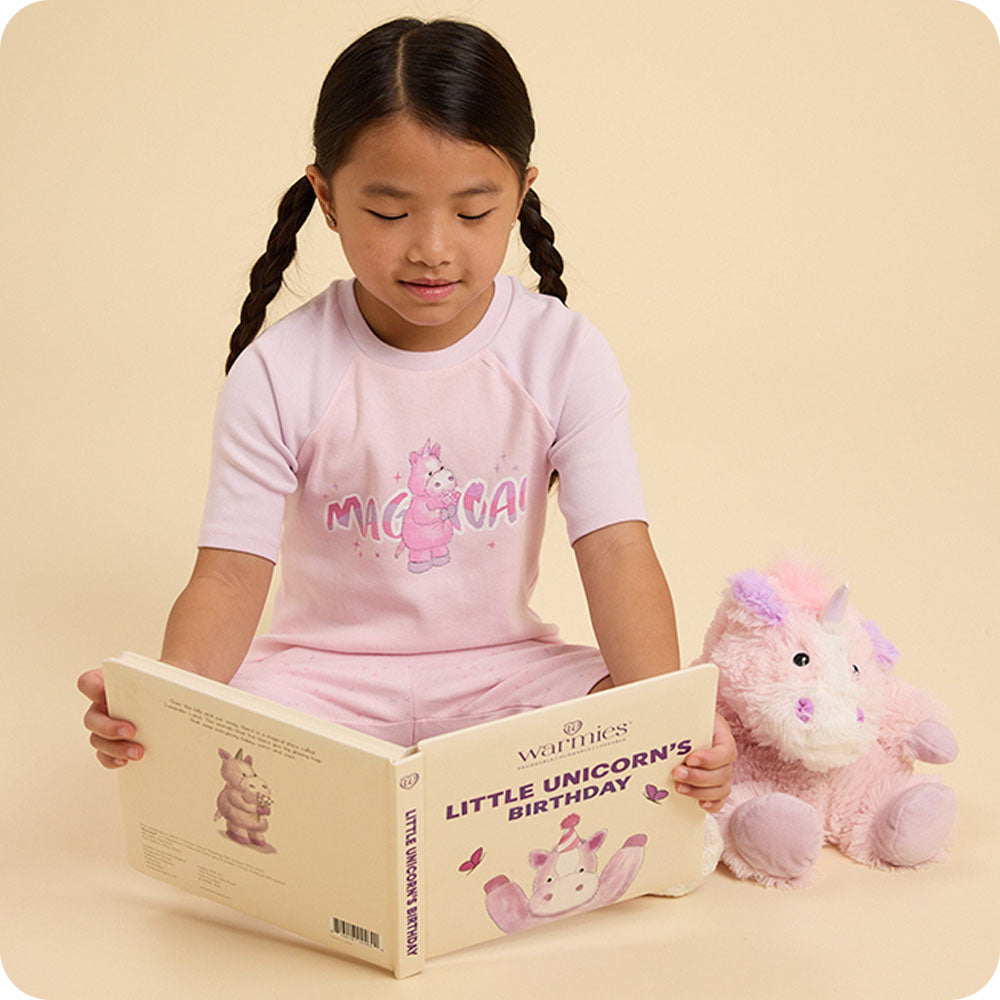 Girl reading Little Unicorn's Birthday warmies book