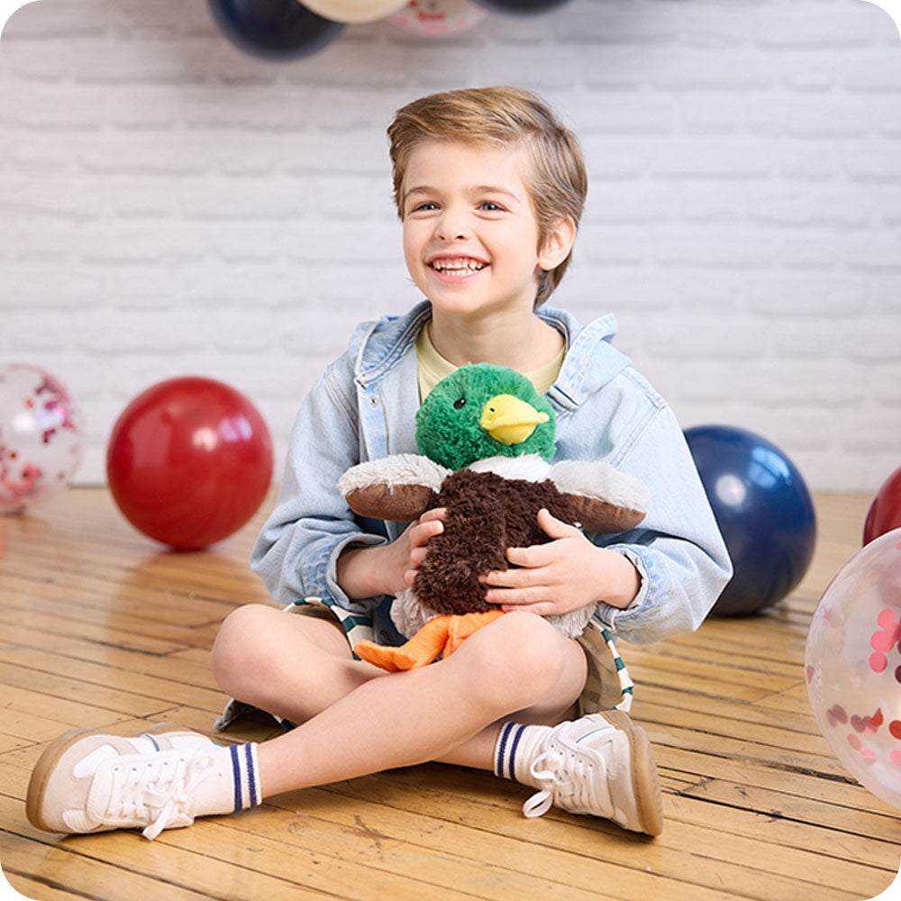 boy hugging mallard duck stuffed animal warmies