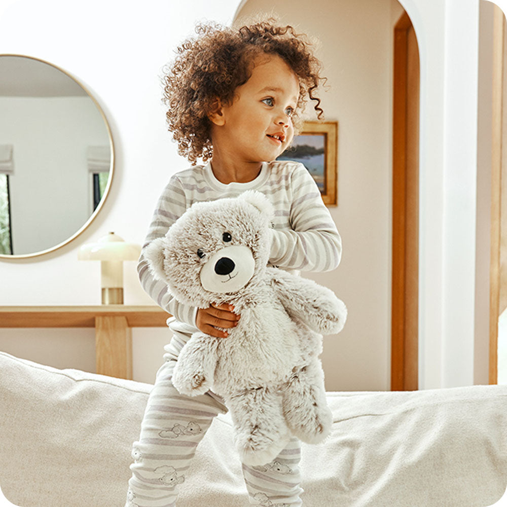child holding marshmallow brown bear warmies lifestyle