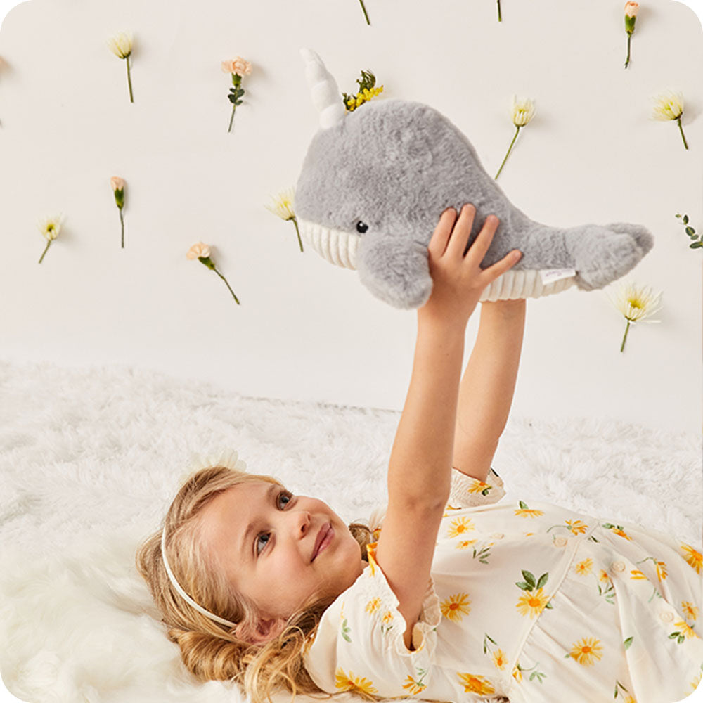 girl holding narwhal stuffed animal