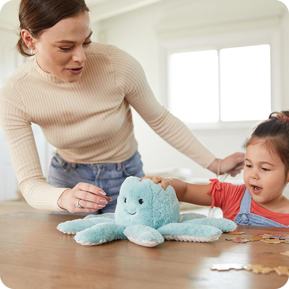 mom and daughter playing with octopus stuffed animal