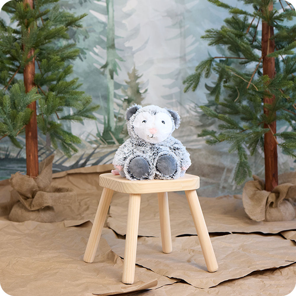 opossum stuffed animal warmies in a woodland setting