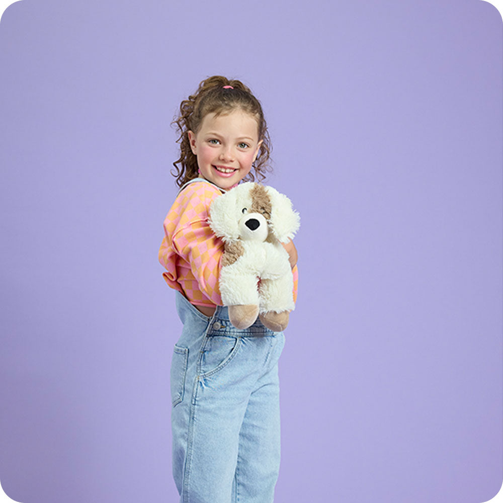 girl holding puppy stuffed animal warmies