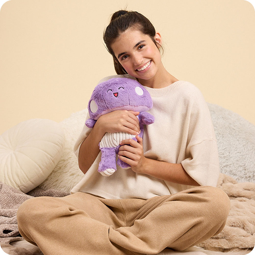 girl holding purple mushroom stuffed animal warmies