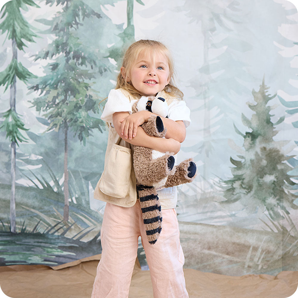 girl hugging raccoon stuffed animal