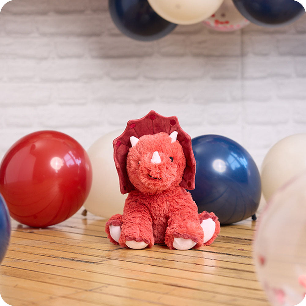 red triceratops stuffed animal with balloons
