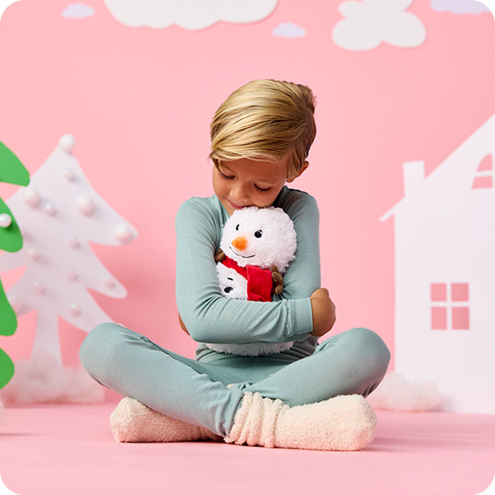 boy hugging snowman stuffed animal