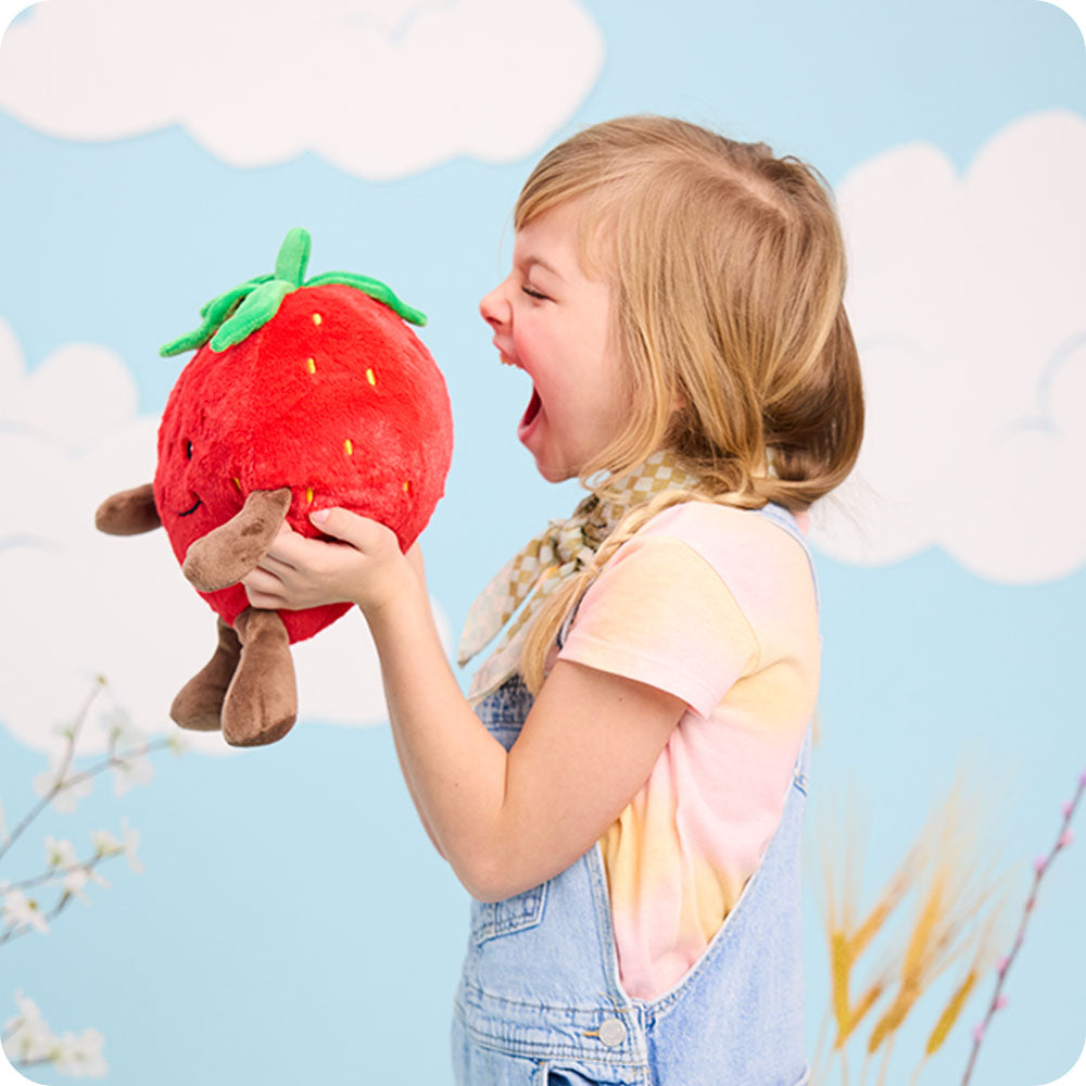 girl holding strawberry stuffed animal warmies