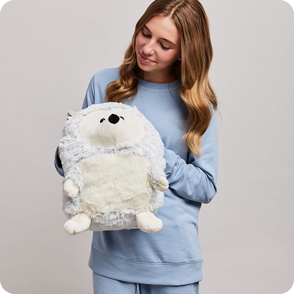 girl holding supersized hedgehog stuffed animal warmies