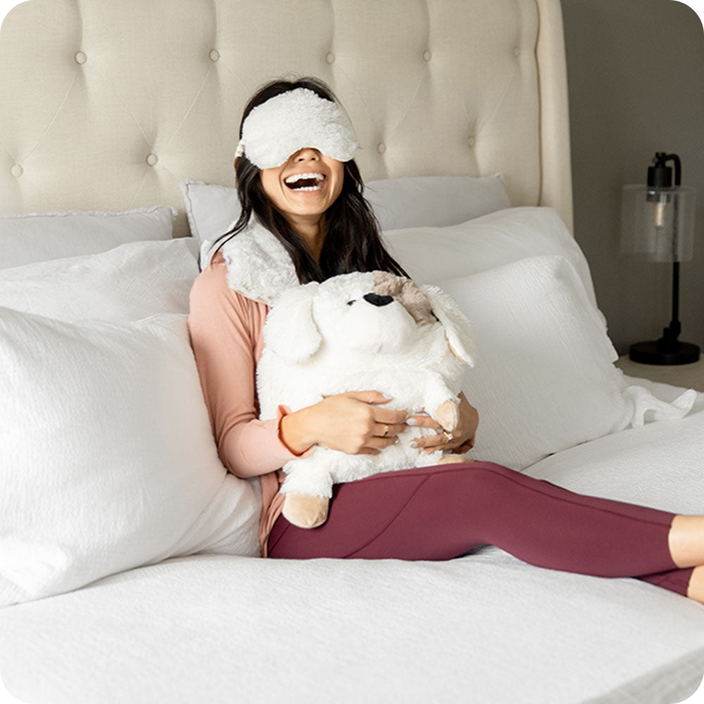 woman relaxing with supersized puppy stuffed animal