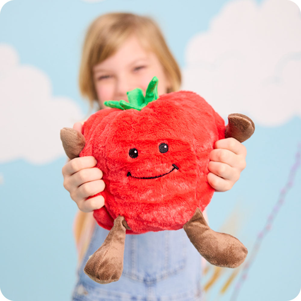 girl holding tomato stuffed animal warmies