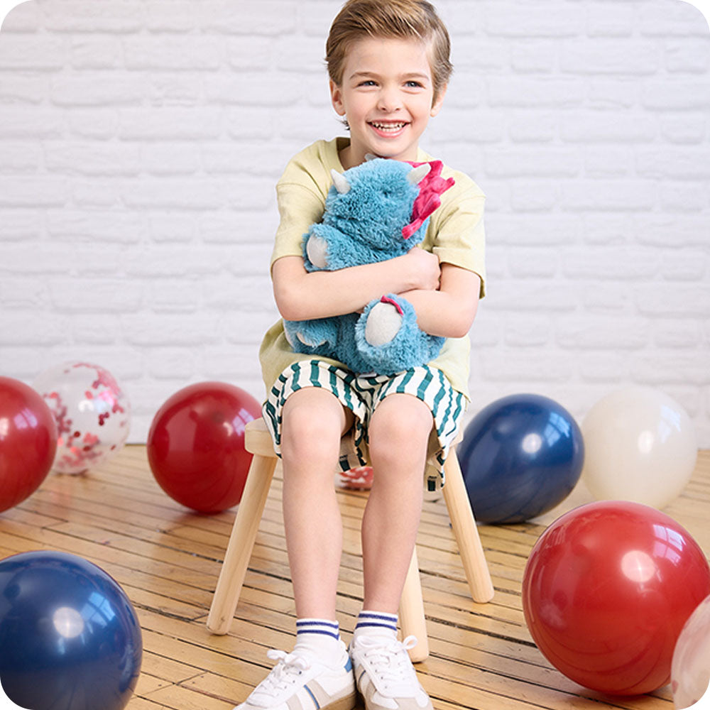 boy hugging triceratops stuffed animal warmies