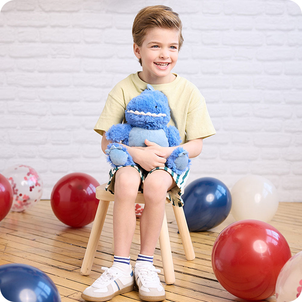 boy hugging dinosaur stuffed animal