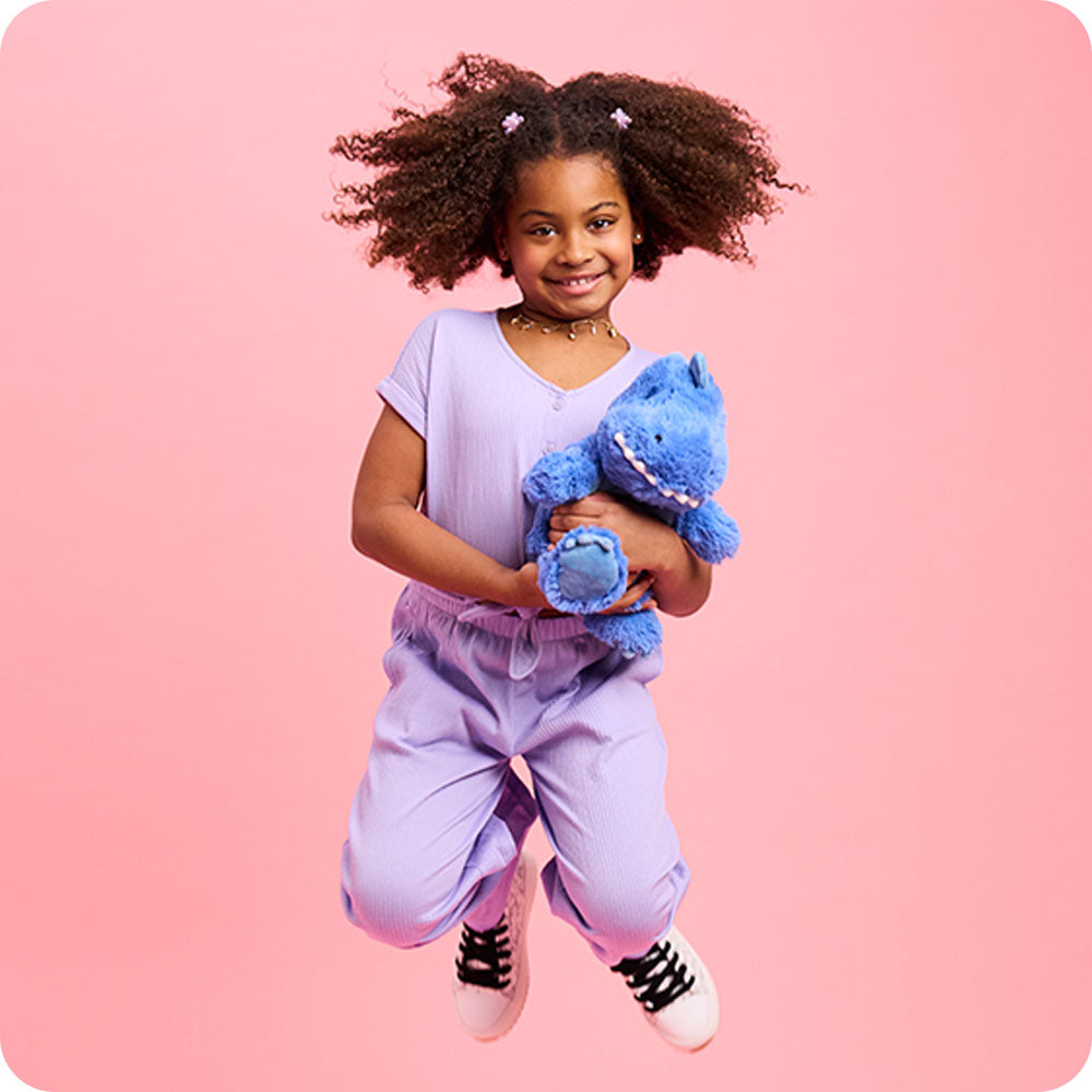 girl jumping with t rex stuffed animal warmies
