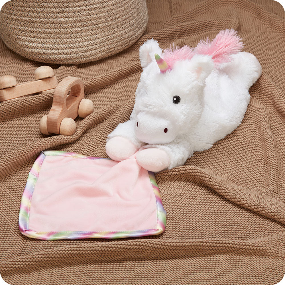 warmies unicorn blankie on a kids blanket with toys