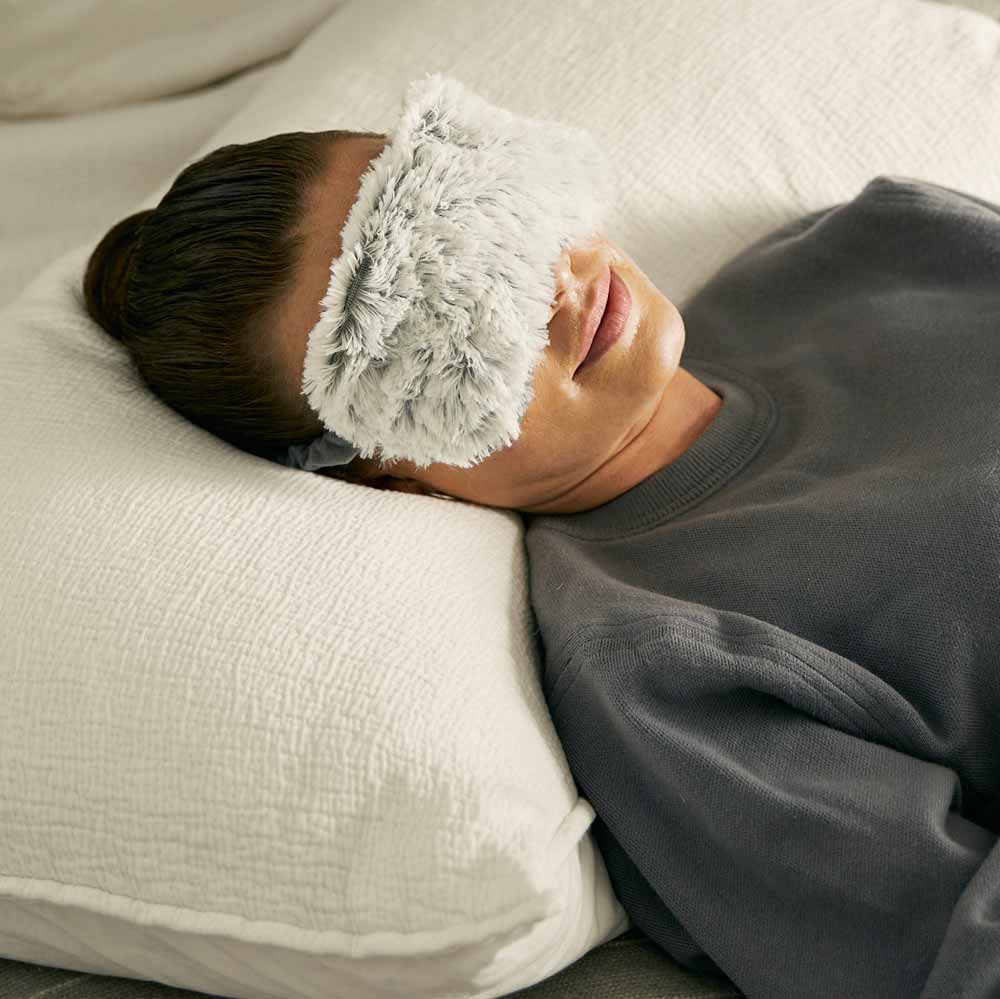 woman sleeping with warmies weighted eye mask