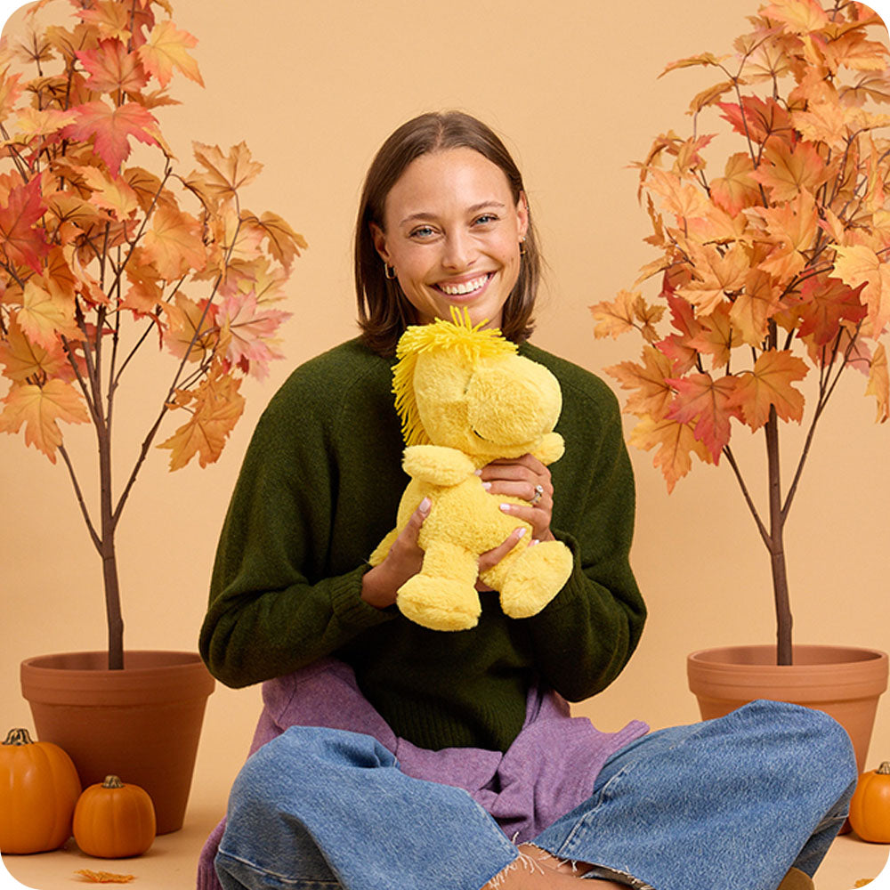 woman holding woodstock stuffed animal warmies