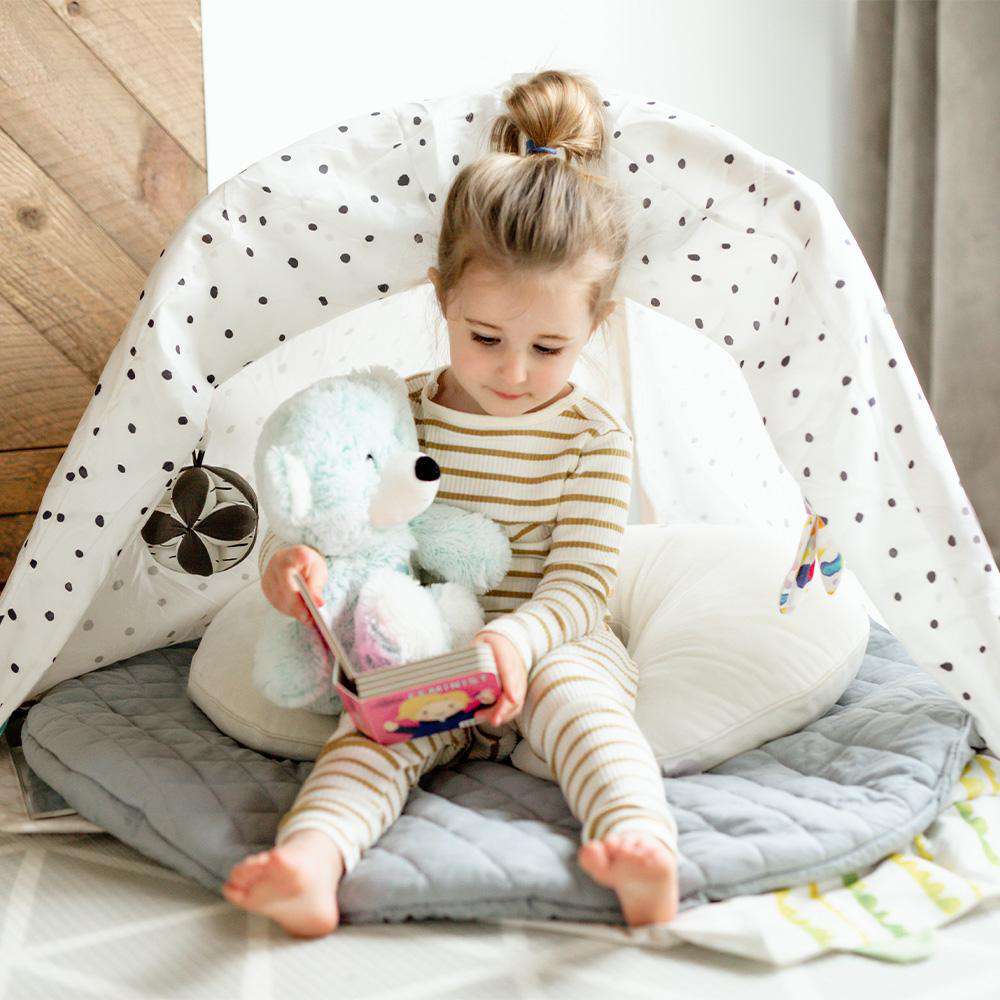 Toddler sitting down with Soft Warm Weighted Celebration Bear Plush Warmies