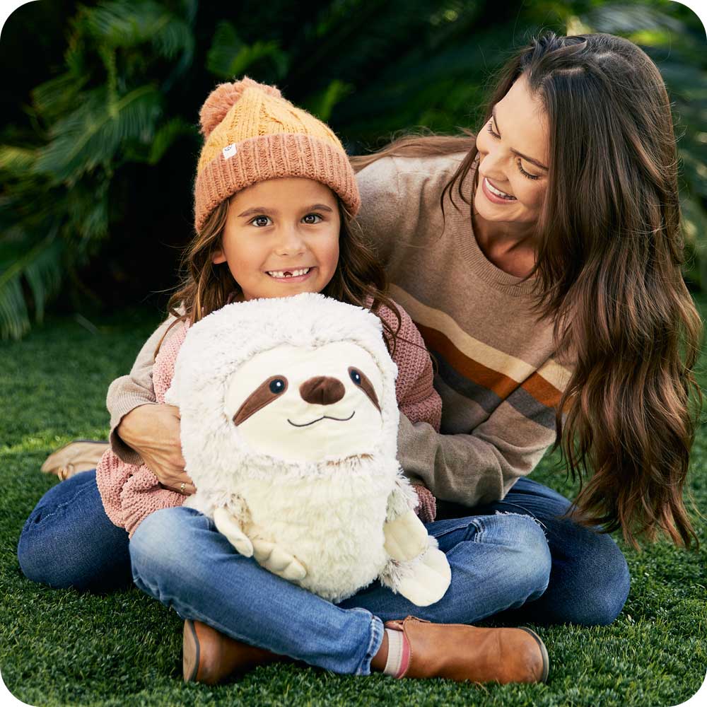 Mother and daughter smiling while holding Soft Warm Weighted Supersized Sloth Plush Warmies