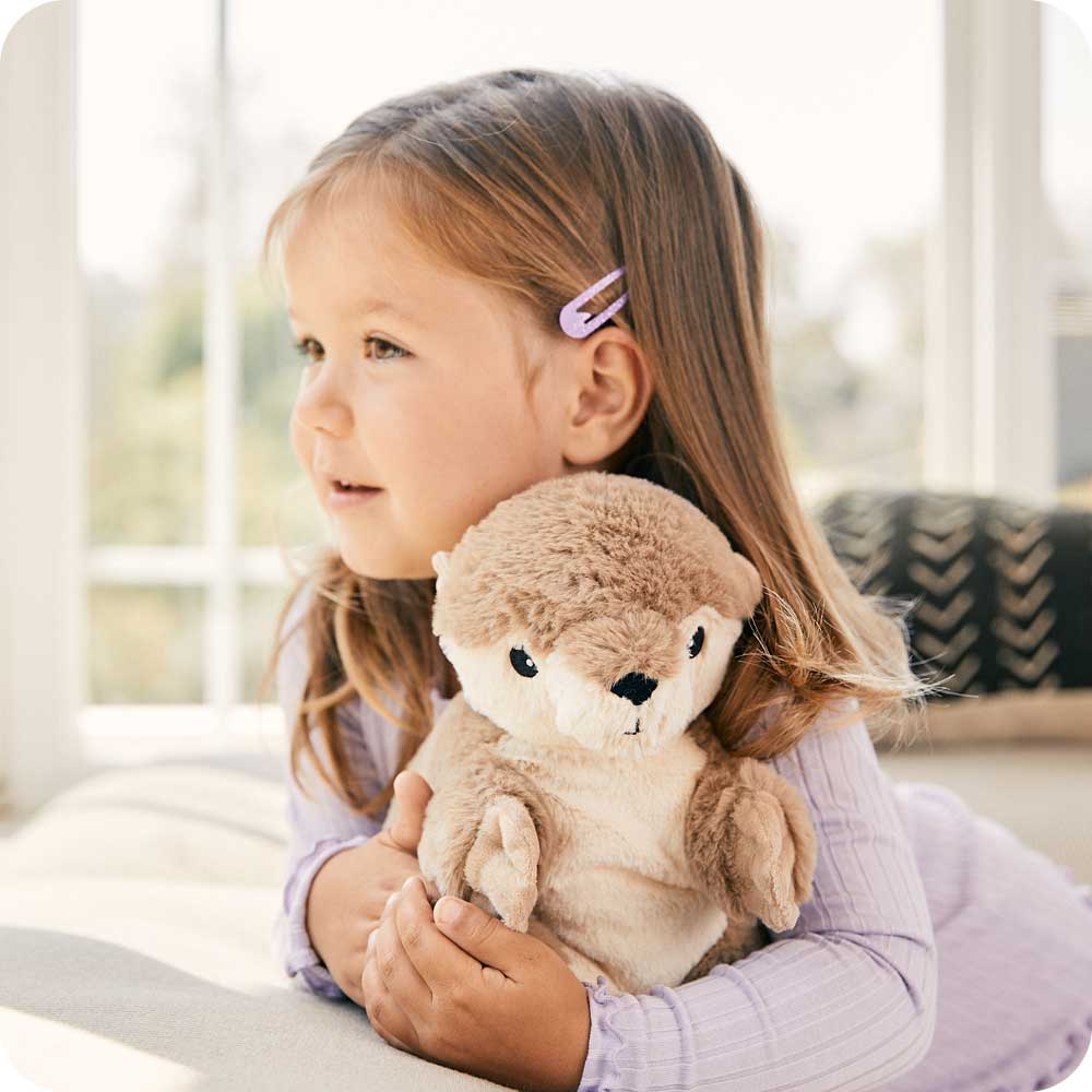 Toddler hugging Cute Weighted Lavender Scented Otter Stuffed Animal Heating Pad Warmies