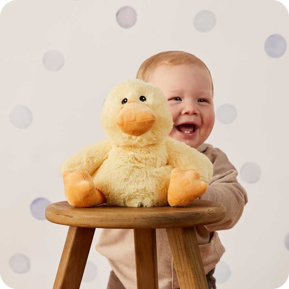 Baby boy holding Cute Weighted Lavender Scented Duck Stuffed Animal Heating Pad Warmies