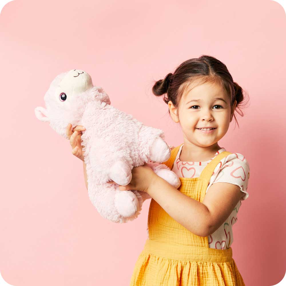 Little girl holding Soft Warm Weighted Pink Llama Plush Warmies