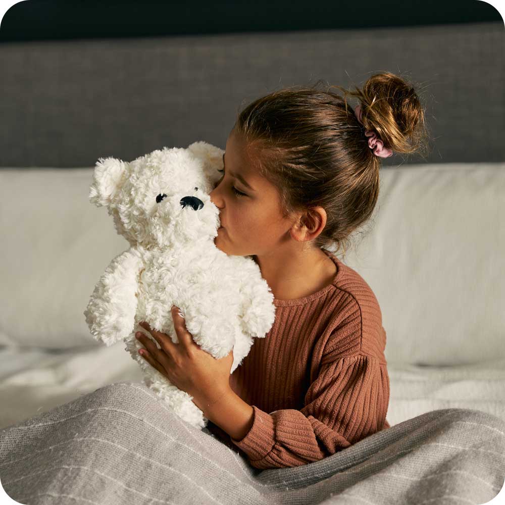 Girl holding her Microwavable Cream Curly Bear Warmies - Warmies USA